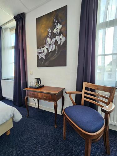 法尔肯堡Hotel 1711的客房配有书桌、椅子和绘画作品