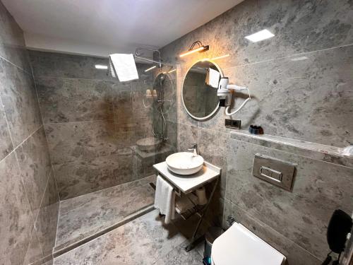 伊斯坦布尔Downtown Sirkeci Hotel的一间带水槽和镜子的浴室