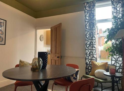 考文垂Coventry Lovely House, Sleeps 4, by Empower Homes的客厅配有桌椅和窗户。