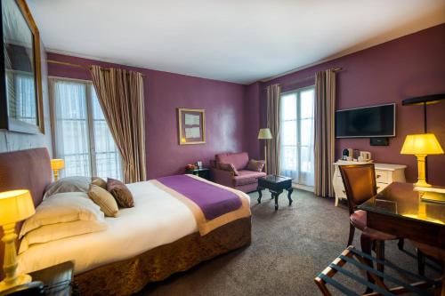蒙彼利埃阿拉贡酒店的酒店客房带一张大床和一把椅子