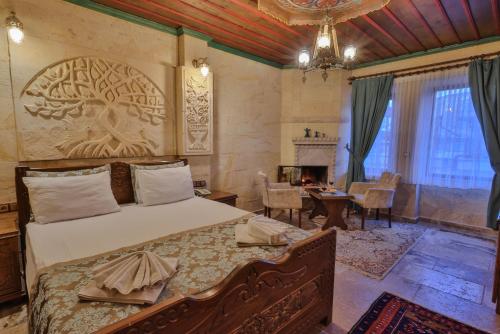 格雷梅Feel Cappadocia Stone House的卧室配有一张床铺,墙上雕刻着一棵树