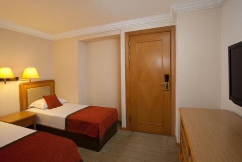 埃拉特Royal Beach eilat的一间酒店客房,设有两张床和一扇门