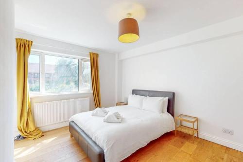 伦敦Cozy 3 bedroom apartment in Brixton的卧室配有一张大白色床和窗户