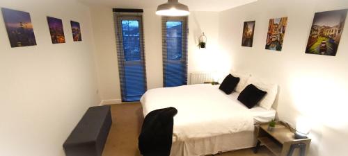 克劳利2 Bed Crawley Apt - Near Gatwick的卧室配有白色的床和2扇窗户。