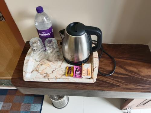 瓦拉纳西Happy Homes的桌子上的茶壶和一瓶水