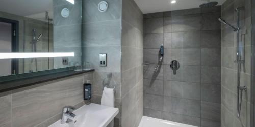 伦敦Maldron Hotel Shoreditch London的一间带水槽和淋浴的浴室