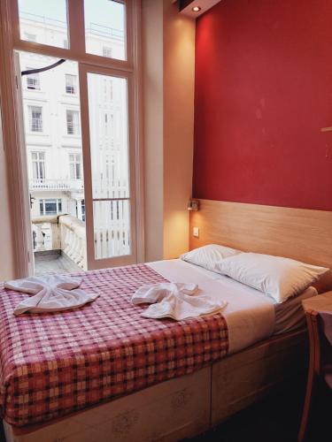 伦敦Carlton Hotel的一间卧室配有一张床,上面有两条毛巾