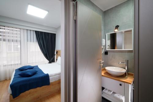 伊斯坦布尔Meet İstanbul Hotel Kadikoy的一间带床和水槽的小浴室