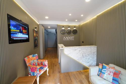 伊斯坦布尔Meet İstanbul Hotel Kadikoy的客厅配有沙发和墙上的电视