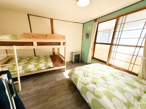 登别Mint / 11min walk to Noboribetsu st的一间卧室设有两张双层床和一扇窗户。