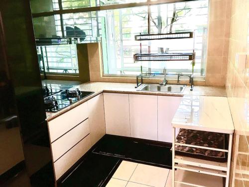 古晋Eden Height Cozy & Spacious Condominiums in City of Kuching的白色的厨房设有水槽和窗户