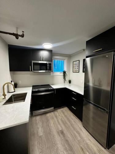哈利法克斯Quaint Queen Suite Central HFX的厨房配有黑白台面和不锈钢冰箱
