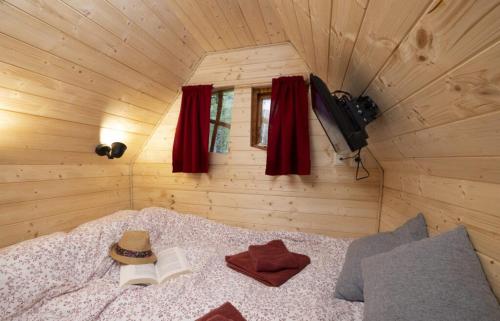 AndryesCamping USHUAÏA Villages Au Bois Joli的一间卧室配有一张带帽子和书籍的床
