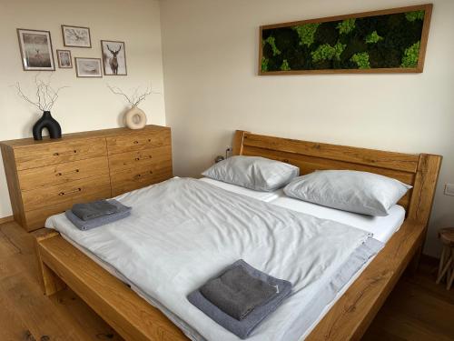 克维尔达Strunzova pila - wellness的一间卧室配有一张带白色床单和枕头的木制床。