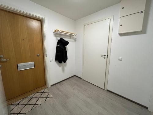 拉赫蒂Tilava huoneisto的一间有门的房间,墙上挂着一件外套