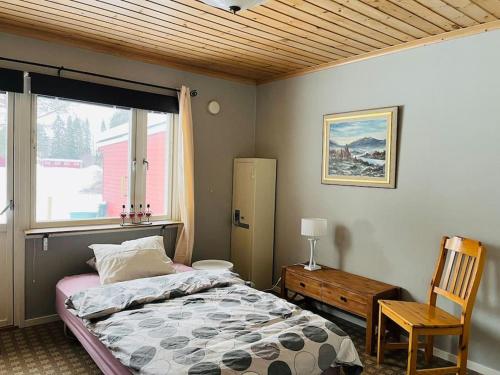 NorsjöVrijstaand huis in Västerbotten的卧室配有床、椅子和窗户。