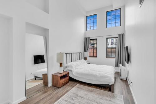 布鲁克林Stylish 2BR Loft - Carroll Gardens - Prime area的白色卧室配有床和镜子