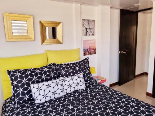 瓜塔维塔Living Club的一间卧室配有一张带黑白枕头的床