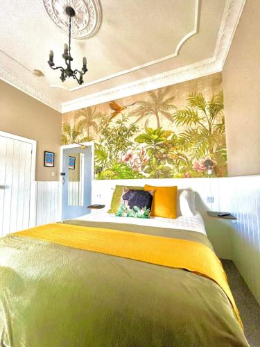 滕比滨海大道1号酒店的一间卧室配有一张带壁画的大型绿色床