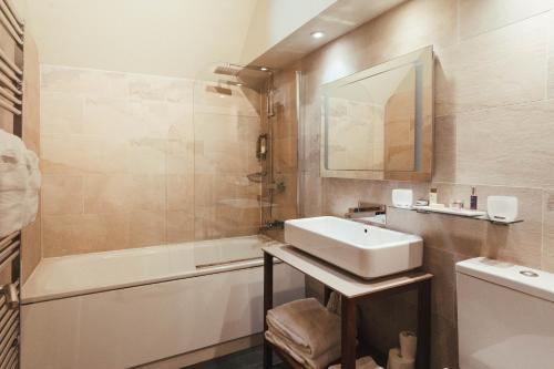 梅德斯通提克特洛特宾馆的浴室配有盥洗盆和浴缸。