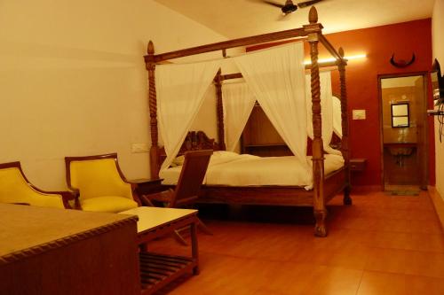 埃尔加德Vacation villa的一间卧室配有一张天蓬床和两把椅子