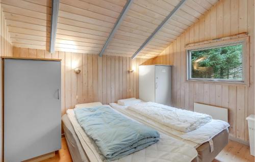 奥克斯伯尔3 Bedroom Cozy Home In Oksbl的木制客房内的一间卧室,配有一张床
