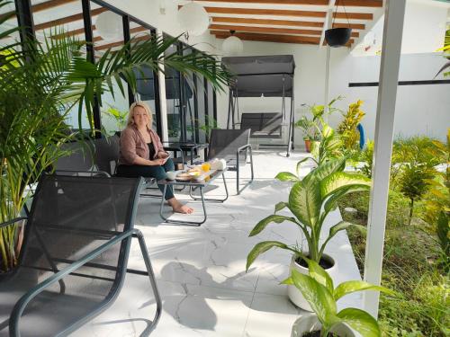 科卢马杜卢Oceana Inn Maldives的坐在植物庭院椅子上的女人