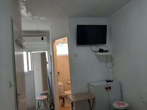 特拉维夫Beach Apartment的一间白色的房间,墙上有电视