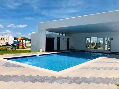 圣米格尔Moderna casa amueblada en residencial privada的房屋前的大型游泳池
