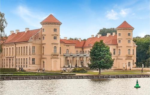 诺伊鲁平Beautiful Ship In Neuruppin With Lake View的一座大型城堡,前面有湖泊