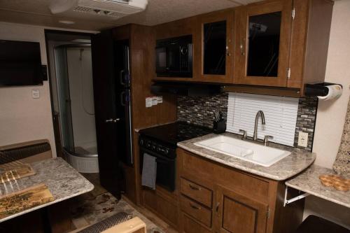 尼斯维尔Quiet Cozy Camper的厨房配有水槽和炉灶
