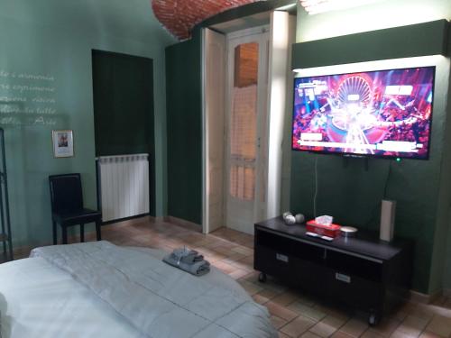 亚历山德里亚I Portici guest house的卧室配有一张床,墙上配有电视