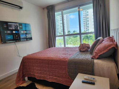里约热内卢Loft Ilha Pura的一间卧室设有一张大床和大窗户