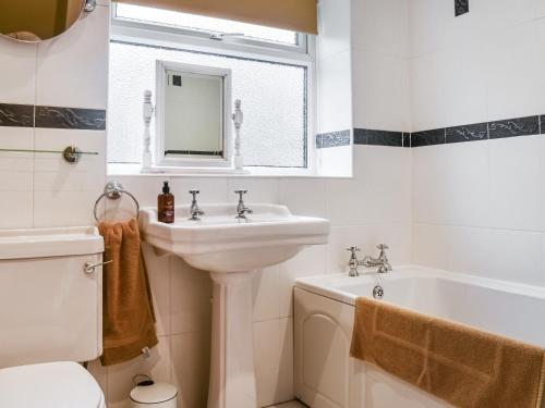 Luddenden FootVintage Cottage的白色的浴室设有水槽和浴缸。