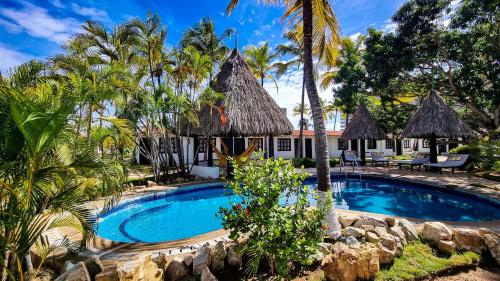 波拉马尔Hotel Margarita Village的棕榈树度假村前的游泳池