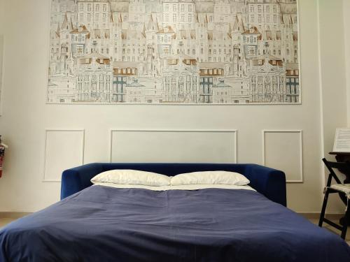 博洛尼亚Bologna Travel Suite的卧室配有一张蓝色的床,墙上挂着一幅画