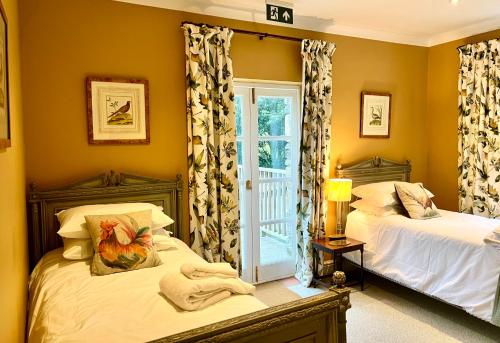 珊顿The Mill House的一间卧室设有两张床和窗户。
