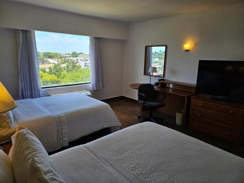 坦皮科费斯特旅馆－坦皮科的酒店客房设有两张床和窗户。