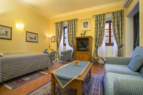 佛罗伦萨卡萨德尔嘉宝 - 豪华客房和套房酒店的酒店客房配有床、沙发和桌子。