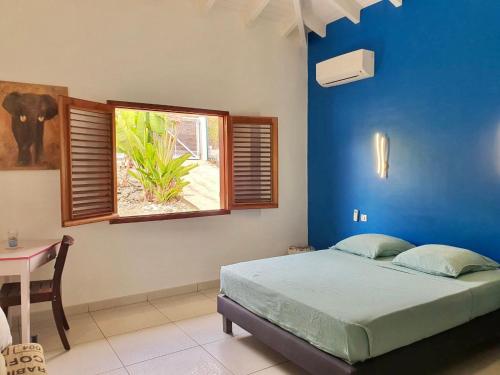 大博格Villa Horizon à Marie-Galante的蓝色的卧室设有床和窗户
