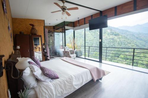 拉维加Magma "Eco Hotel Cabañas"的一间卧室设有一张床和一个大窗户