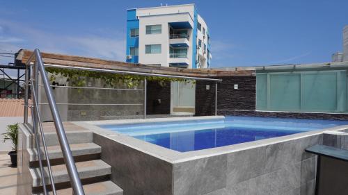 曼塔YORMARI HOTEL的一座带楼梯的游泳池,位于大楼旁