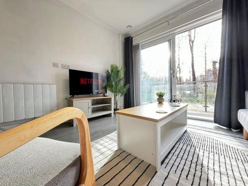 赫默尔亨普斯特德Luxury Canal-side Apartment, Hemel Hempstead, Free parking, Perfect for Contractors的客厅设有桌子和大窗户