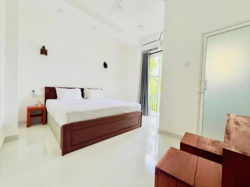 韦利格默Lavish Weligama的白色的卧室设有床和窗户