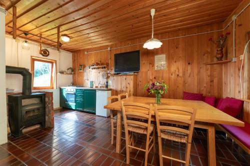 OrtnekFamily Peace Chalet Brinovska & Scenic Mt Views的一间带木桌和炉灶的用餐室