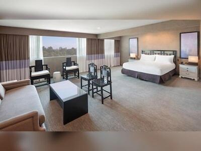洛杉矶日落大道豪华酒店的大型酒店客房,配有床和沙发