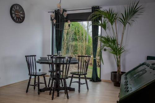 KortenbergMeerbeek Unwind的一间带桌椅和时钟的用餐室