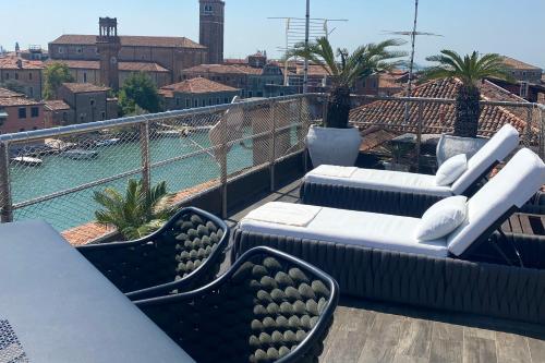 穆拉诺MURANO Suites BOUTIQUE Apartments的阳台配有沙发,享有游泳池的景色