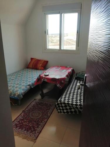 伊夫兰Appartement Jardin d'Ifrane的客房设有两张单人床和一扇窗户。