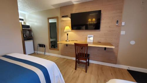 纳奈莫港口之灯汽车旅馆的一间卧室配有一张床和一张书桌及电视